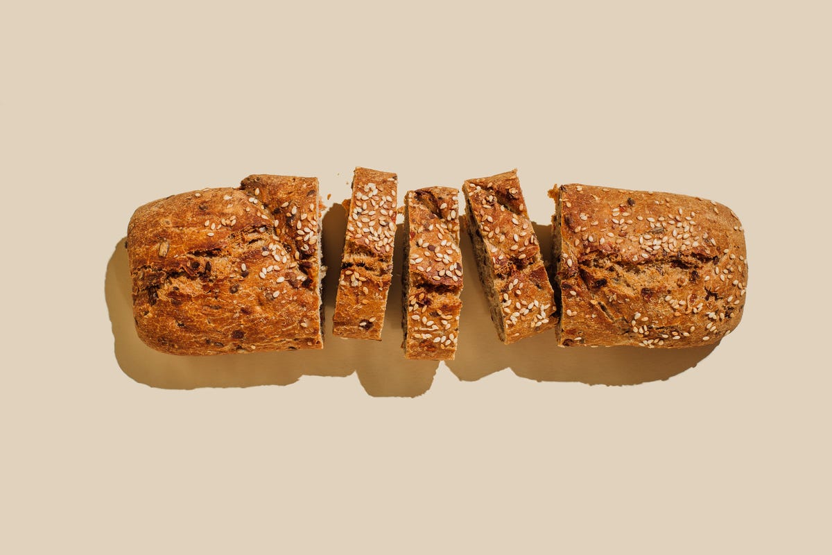 Sliced seeded bread on beige background. 