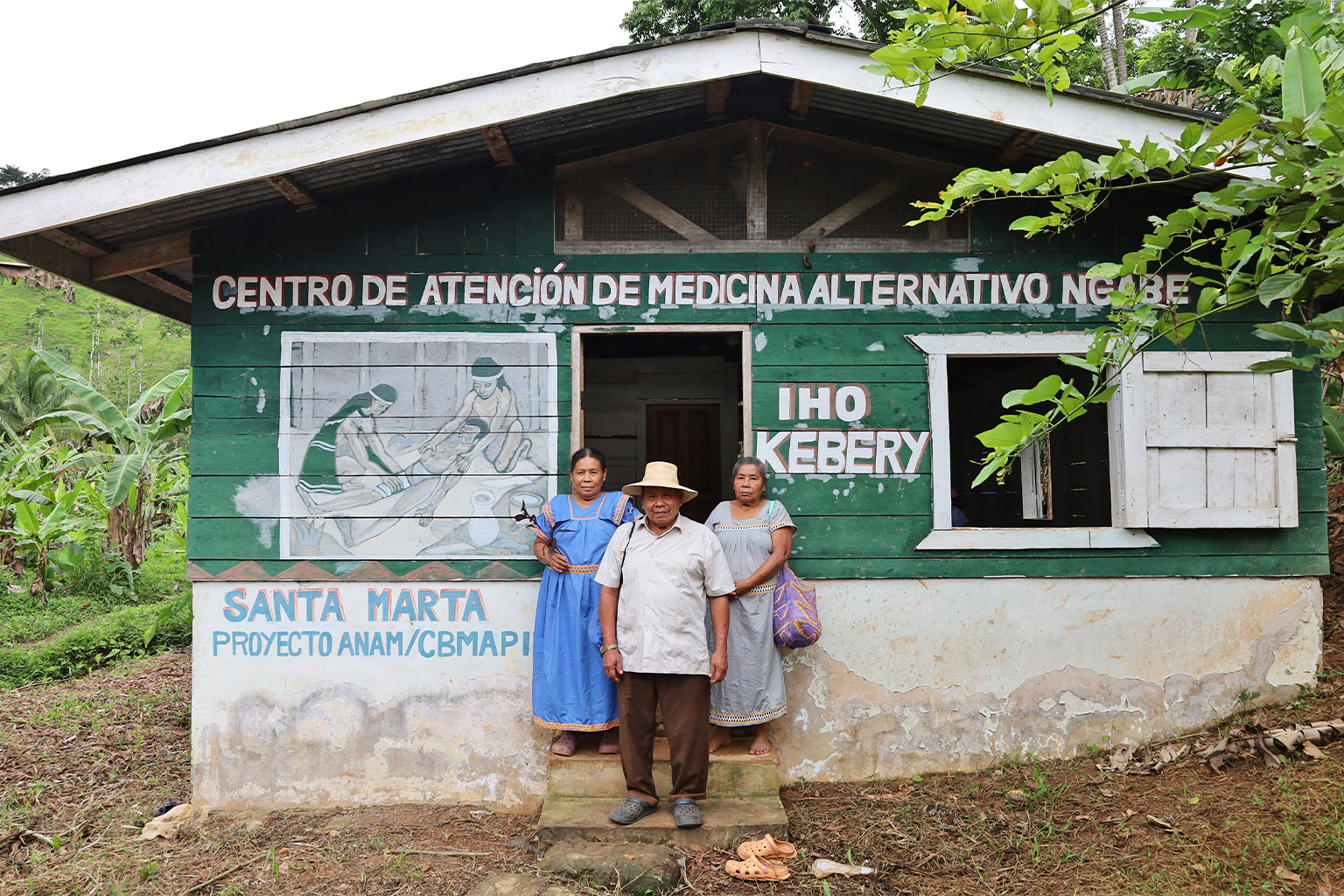 Santa Marta's three traditional medicine doctors, Viviana Montero (left), Mauricio Martínez and Elicia Martínez, stand in front of the town health clinic Iho Kebery.