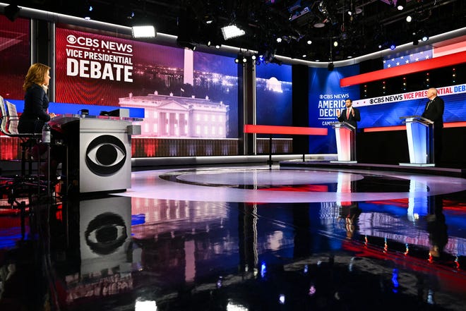 US Senator and Republican vice presidential candidate J.D. Vance (C) and Minnesota Governor and Democratic vice presidential candidate Tim Walz (R) participate in the Vice Presidential debate hosted by CBS News at the CBS Broadcast Center in New York City on October 1, 2024.