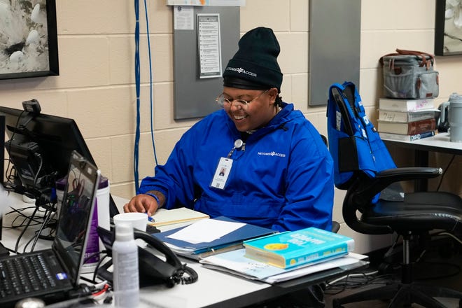 Dee Dill, a peer support specialist for the Community Mobile Team, works at his desk at Netcare Access on Wednesday in Columbus. The crisis response team helps with mental crises in the community to divert unneeded police response.