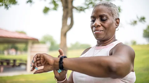 Getty Images A woman checks her smartwatch outdoors on a walk (Credit: Getty Images)