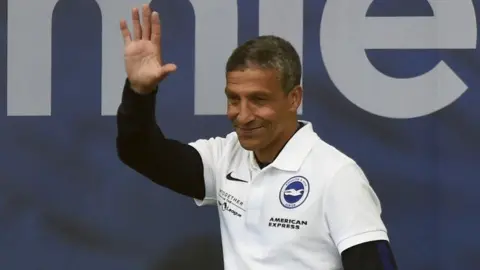 Getty Images Chris Hughton wearing a white t shirt at Albion's victory parade in 2017. 