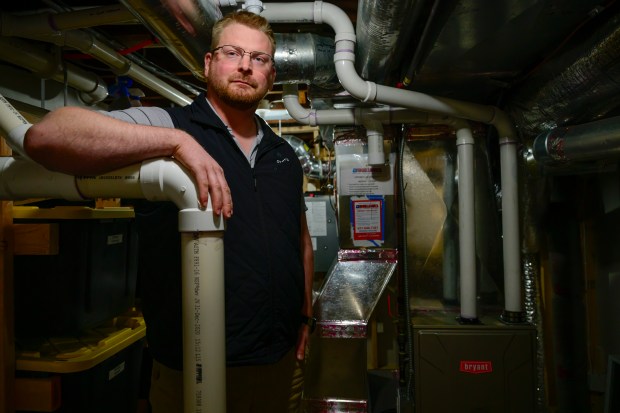 Tanner Wilde standing next to a new furnace he was provided by The Snelling Company. 