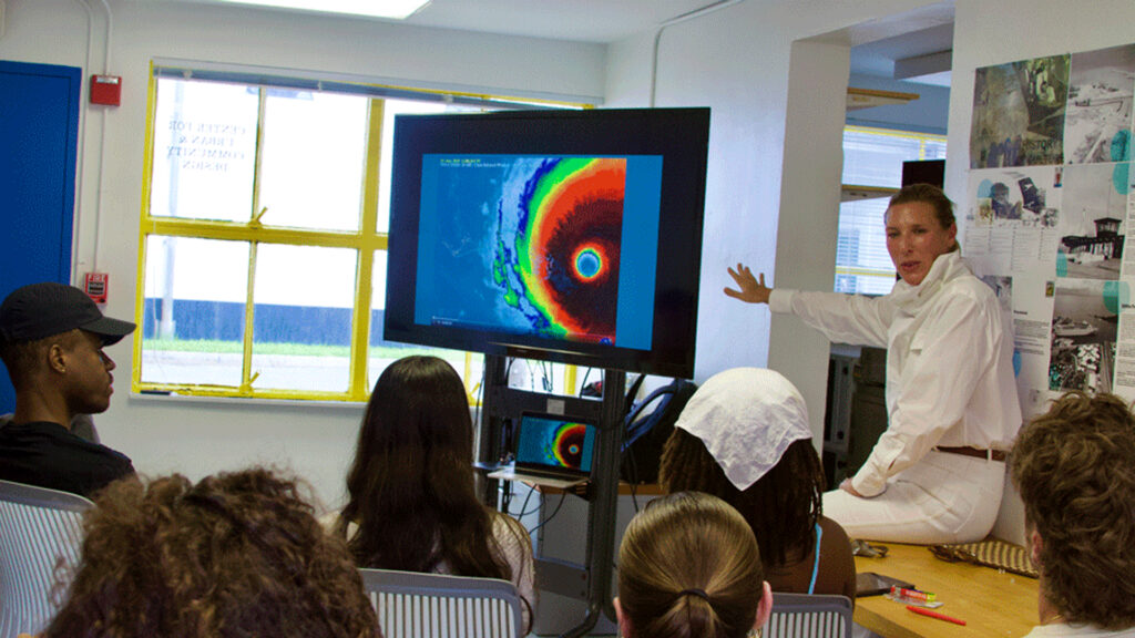 Elizabeth Greig, co-director of the University of Miami's Global Institute for Community Health, explains to architecture students how Dorian's impact was more severe because of the time it spent over the northern Bahamas. (Photo by Catherine Calhoun/University of Miami)