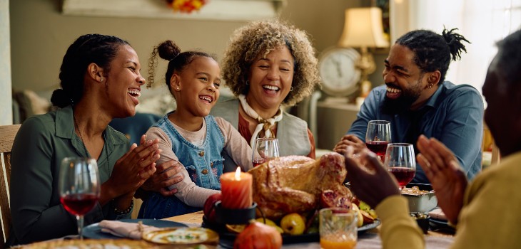 A family gathered around a table and laughing 