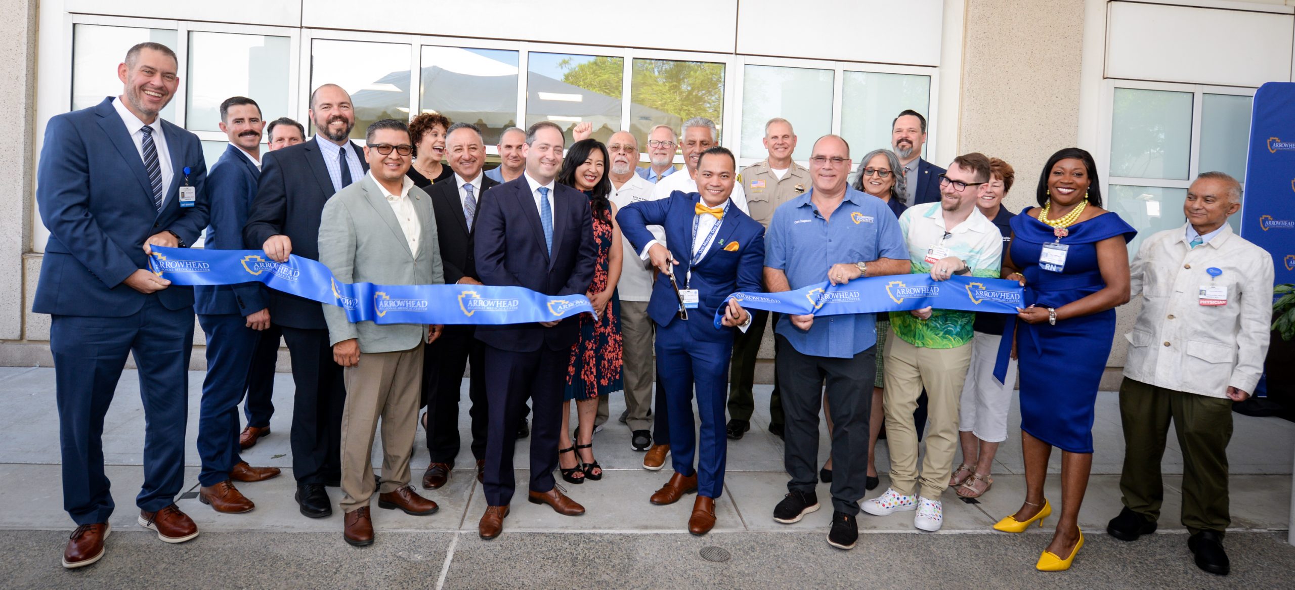 A group of professionals holding a ribbon at a ribbon-cutting ceremony.