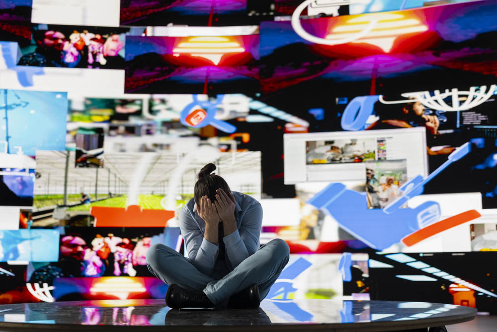 Young man stares at smartphone in distress symbolizing toxic impact of social media on mental health. Likes, posts and endless scrolling lead to stress, anxiety and depression. Overwhelmed user.