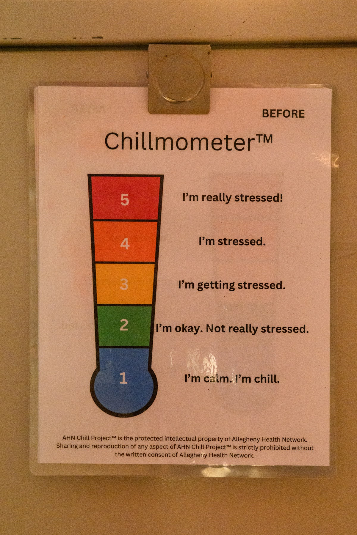 A printed chart titled "Chillmometer" rates stress levels from 1 (calm) to 5 (really stressed), with descriptions for each level, attached to a surface.