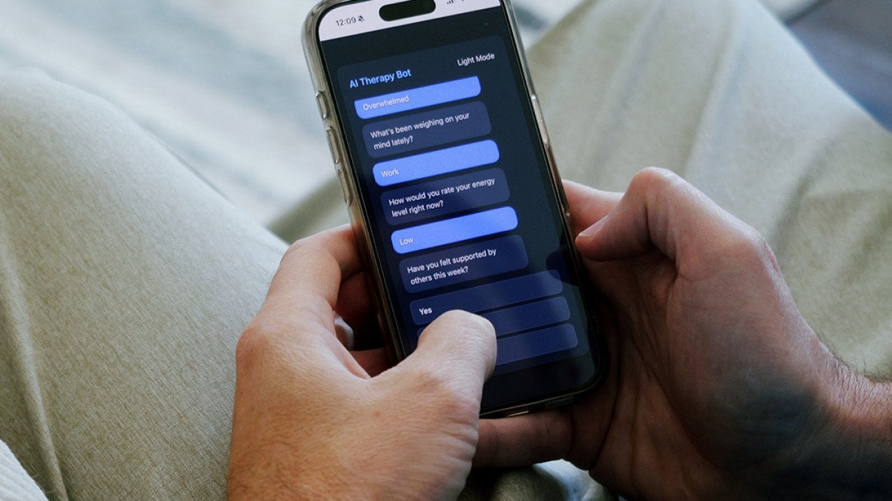 A man having a conversation with an AI therapy bot using a smartphone.