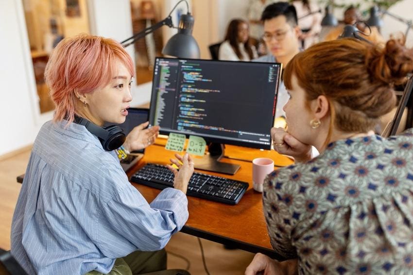 Creative businesswomen discuss over new coding program in the office