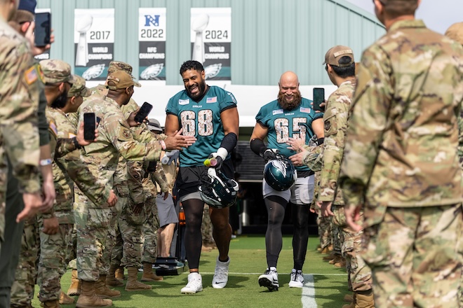Jordan Mailata (left) and Lane Johnson greet service members.