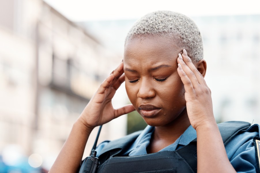 A police officer touching her forehead