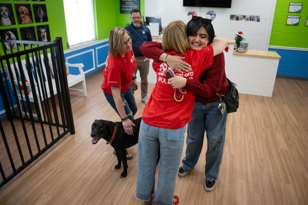 Ashlee Chaidez, right, hugs SPCA volunteer Sara Broene after being reunited with her dog, Duck, after six months apart while Chaidez sought psychiatric care, on Saturday, Dec. 13, 2025, at Hounds Town dog daycare and boarding in Denver. (Photo by Timothy Hurst/The Denver Post)