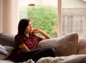 Teen sitting on the couch looking off to the side