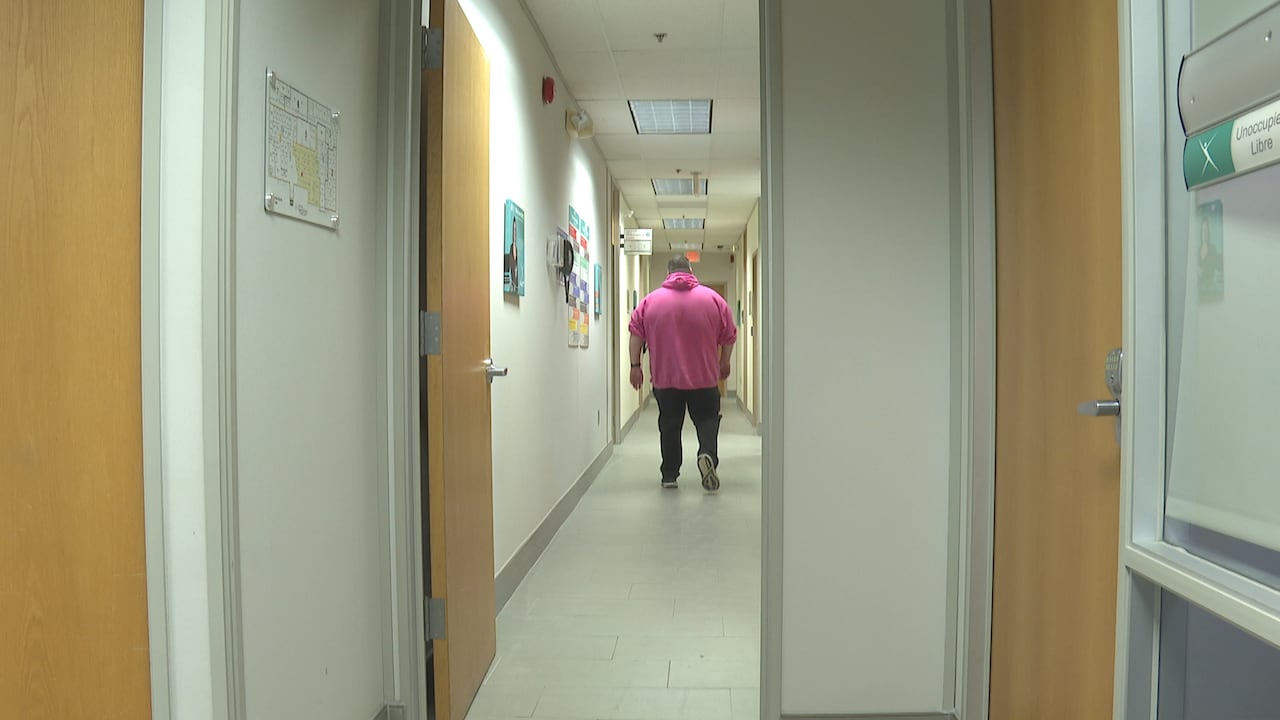 A man walking down a hallway.