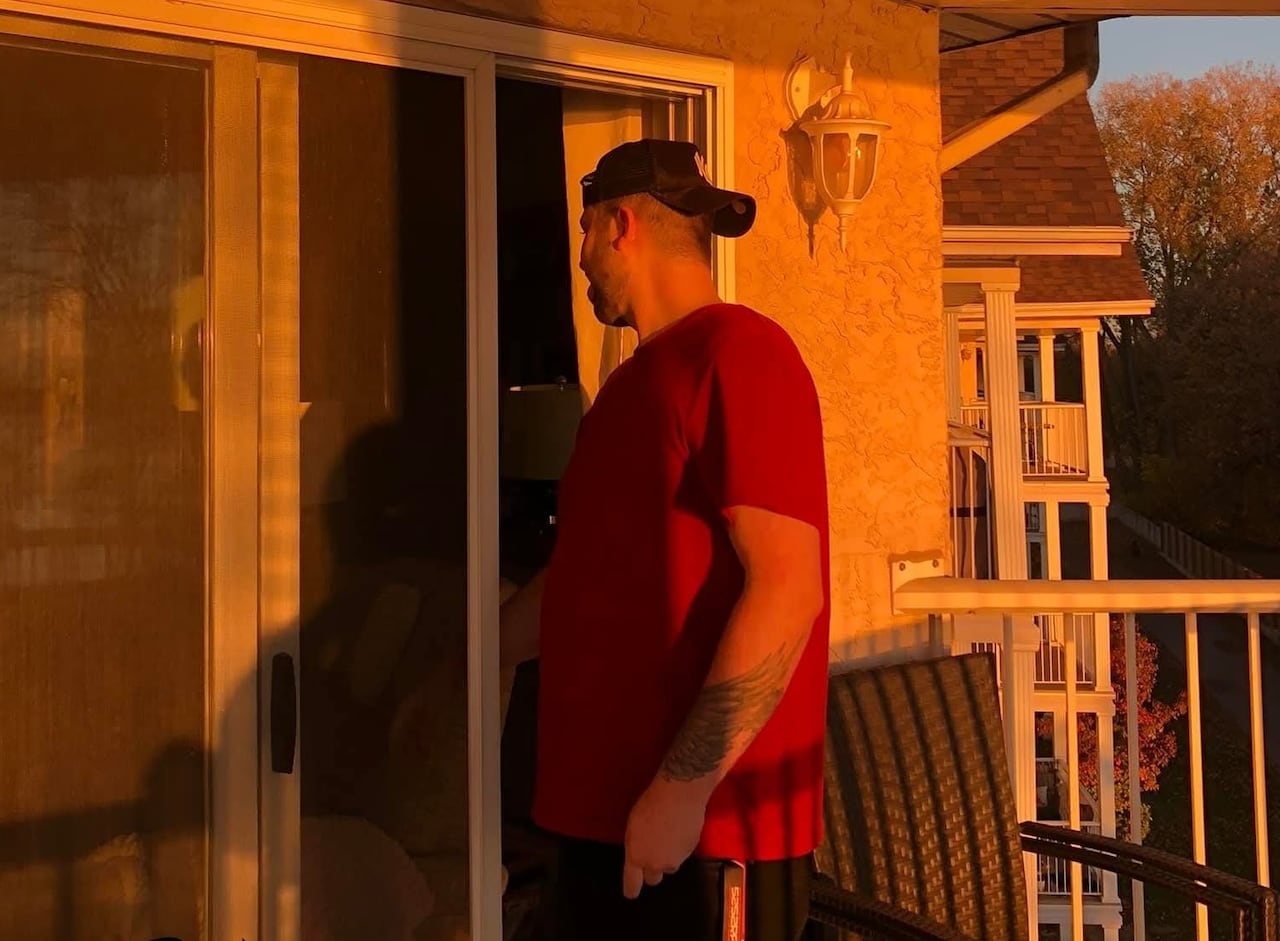 A man turns to go into a house.