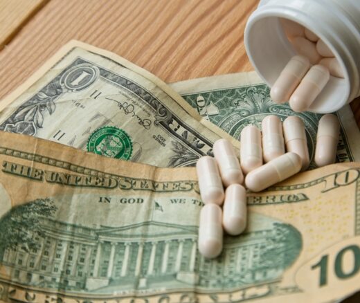 Prescription medication pills from a bottle on a $10 bill.