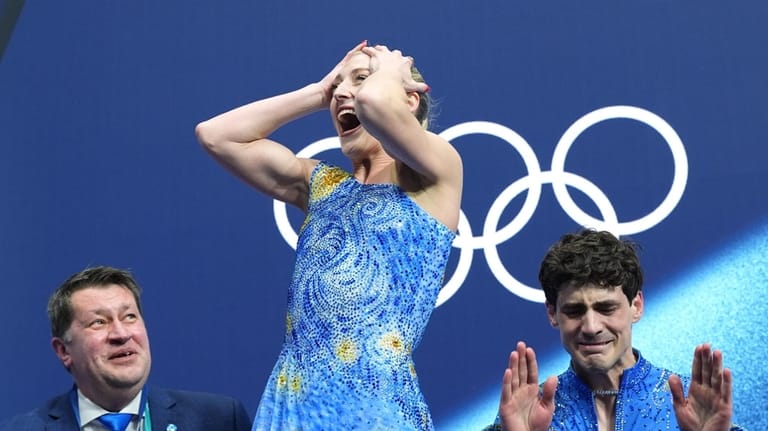Piper Gilles, center, and Paul Poirier, right, of Canada react...
