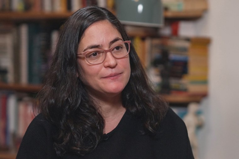 A woman wearing glasses with long dark brown hair