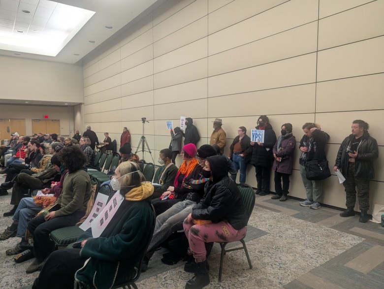 People sitting and standing in a room. 