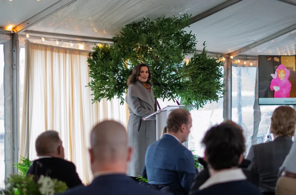 Gov. Whitmer addresses a group inside a tent-like facility.