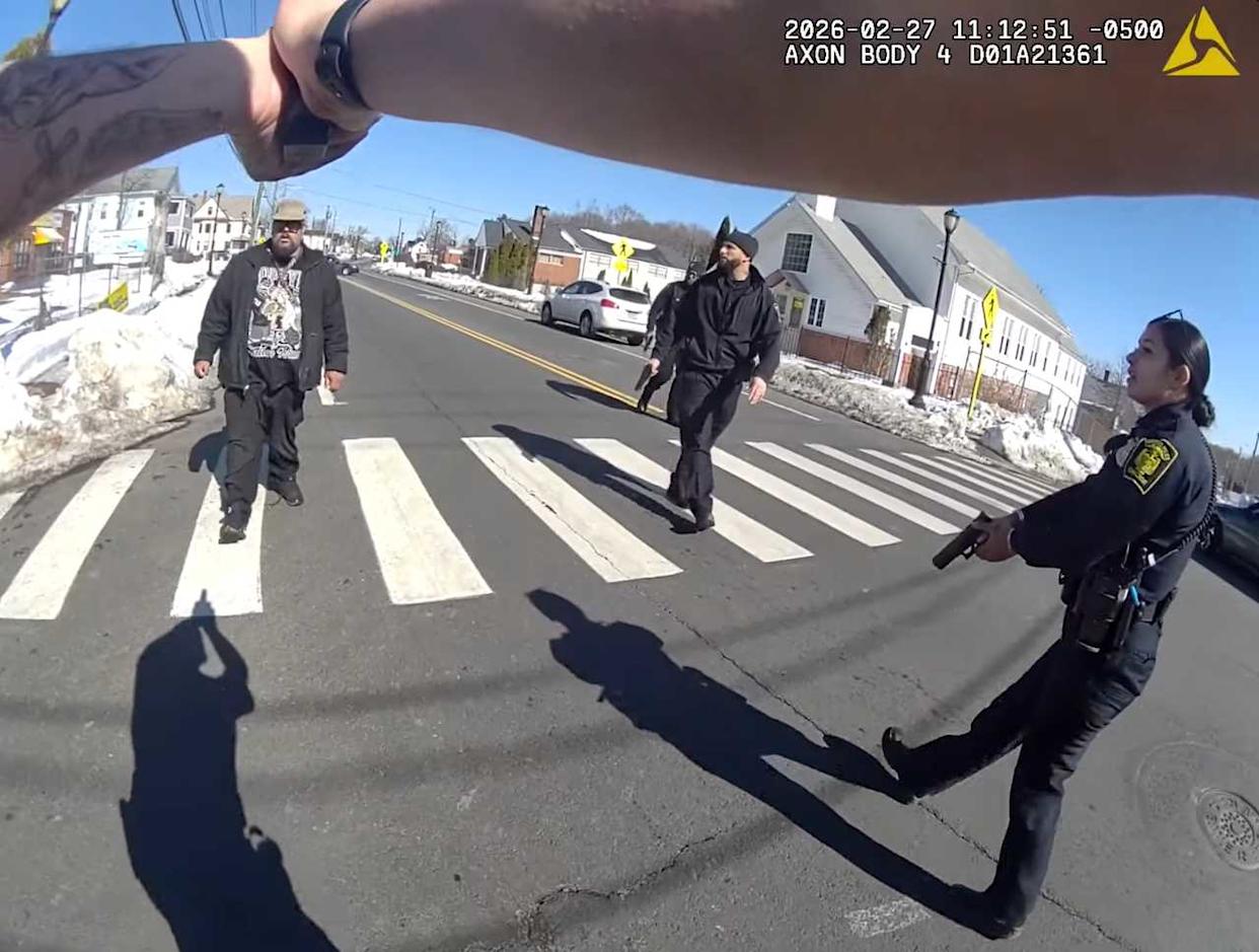 A police officer points a gun at a knife-wielding Steven Jones at the intersection of Hartford's Blue Hills Avenue and Euclid Street on Friday, Feb. 27, moments before pulling the trigger. Jones later died of his injuries.