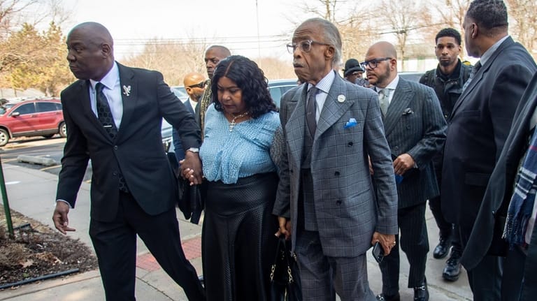 Attorney Ben Crump, left, and the Rev. Al Sharpton escort...