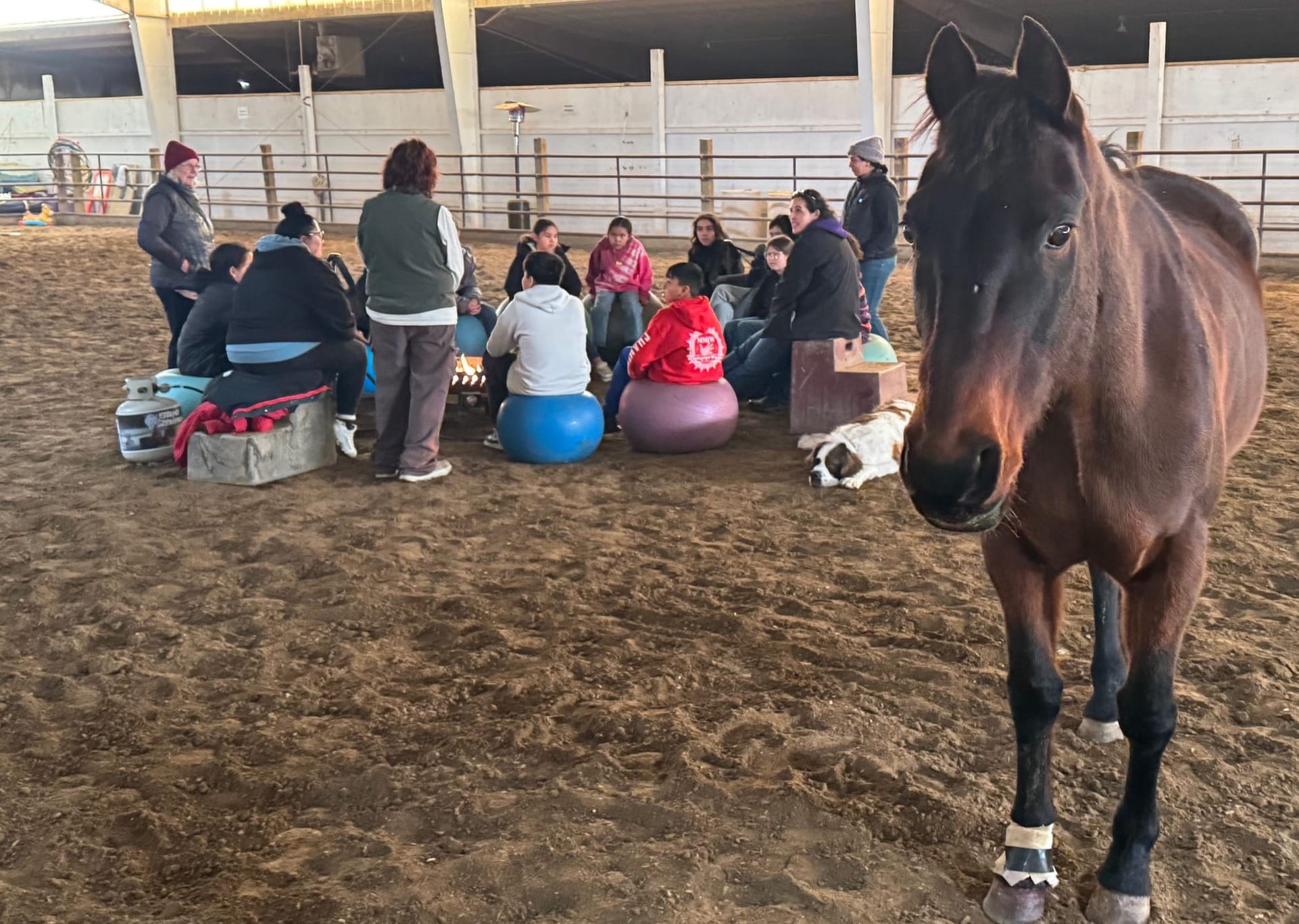 A horse stands by as children gather during a group therapy session at Red Horse Healing in Rapid Valley, S.D., on Feb. 21, 2026.