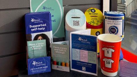 Mental health support information leaflets from Mind and a red memory cup in honour of the men who died.