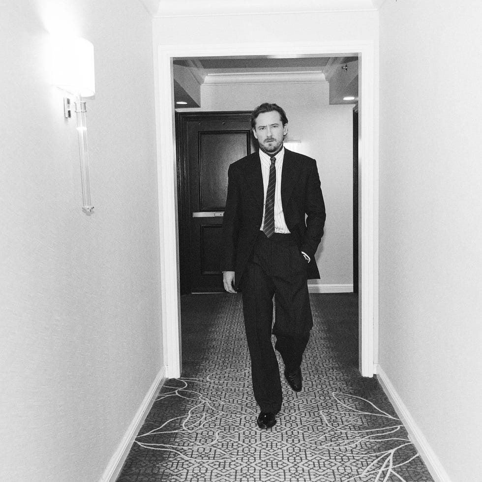 a person walking down a hotel corridor dressed in formal attire