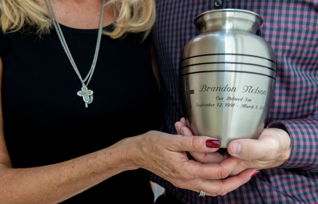 Rose and Allen Nelson hold an urn of their son Brandon's ashes at their Santa Monica home on Sunday, October 21, 2018. Brandon died last March at age 26 after hanging himself in an unlicensed Sovereign Health home. Rose wears Brandon's crosses. (Photo by Mindy Schauer, Orange County Register/SCNG)