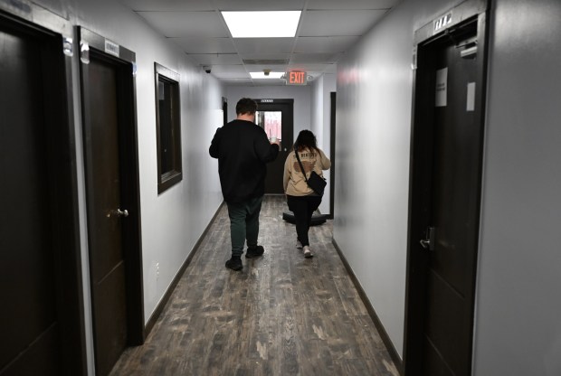 Ethan Ortengren, 18, who has autism, left, and Dezart Stover, a behavior technician (BT), walk down a hallway at Seven Dimensions Behavioral Health as they head outside for exercise in Evergreen, Colorado, on March 16, 2026. (Photo by RJ Sangosti/The Denver Post)