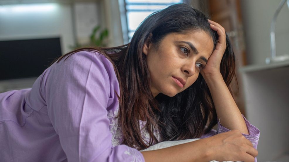 A woman can be seen leaning on her hand in this undated photo.{ } Research from the American Heart Association suggests a link between mind, heart and body, emphasizing the importance of both mental and physical health. (WWMT){p}{/p}