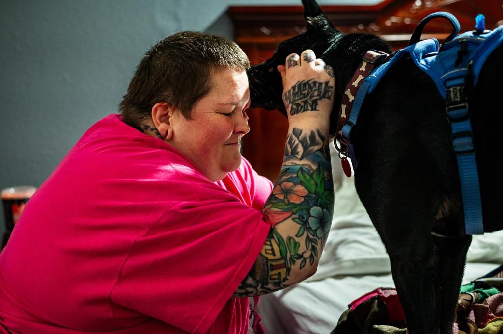 Suzanne Stephens receives a kiss from her dog Sage in her motel room at Rest Inn & Suites March 10, 2026. Stephens has spent the past two years unhoused due to medical difficulties and has just recently moved into the motel with help from the Tulsa Day Center. 