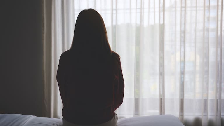 Person sitting on bed file image