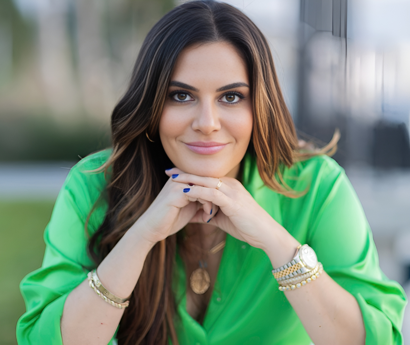 a woman with dark brown hair in a green shirt