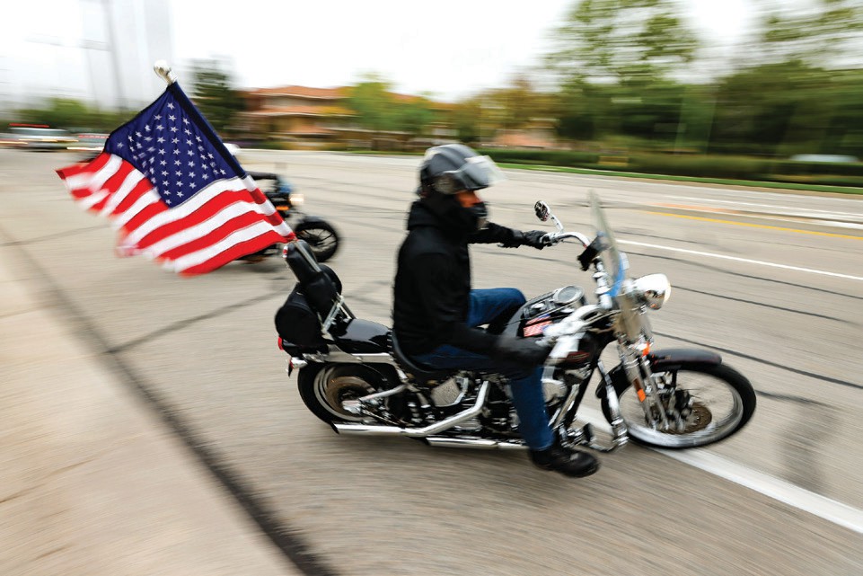 GEARING UP—Top left, a rider carries the Red, White and Blue on a 2024 Sgt. Ron Helus Ride for the Blue. Bottom left, Simi Valley policce officers observe the start of the ‘24 ride. Above, John Short, who helped create the event, in a solemn moment. Acorn file photos