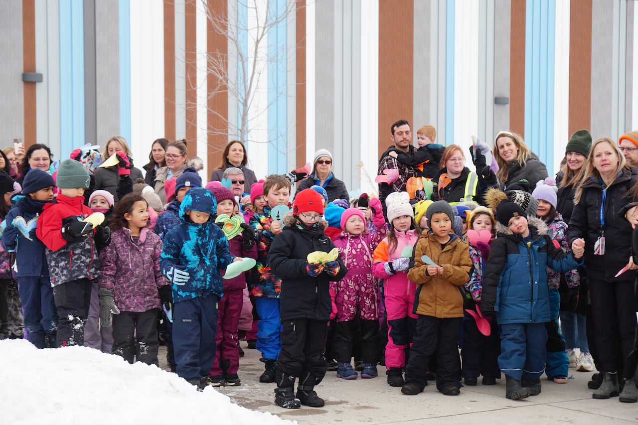 A large group of students is seen standing outside.