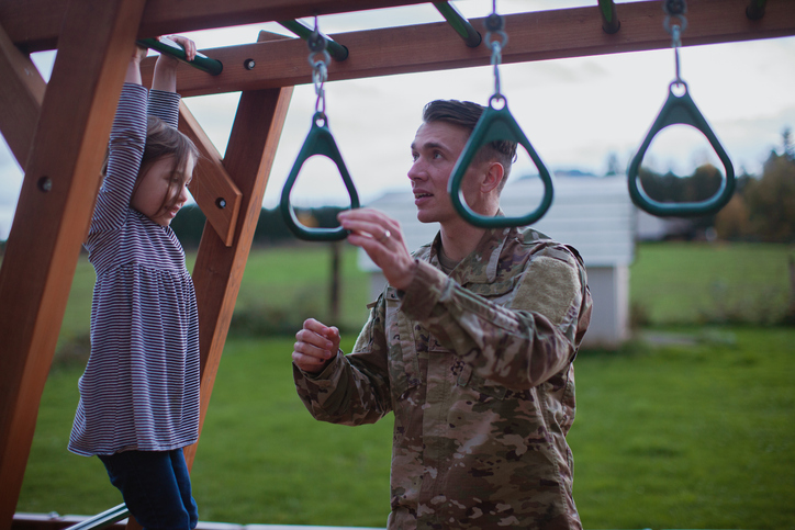 Large Family With Father in Military Uniform Playing Happily Outdoors