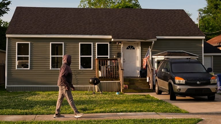 A person passes the home where a mass shooting occurred...