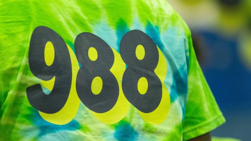 Yellowish tie-dye T-shirt with the phone number 988 for the National Suicide Prevention Lifeline  