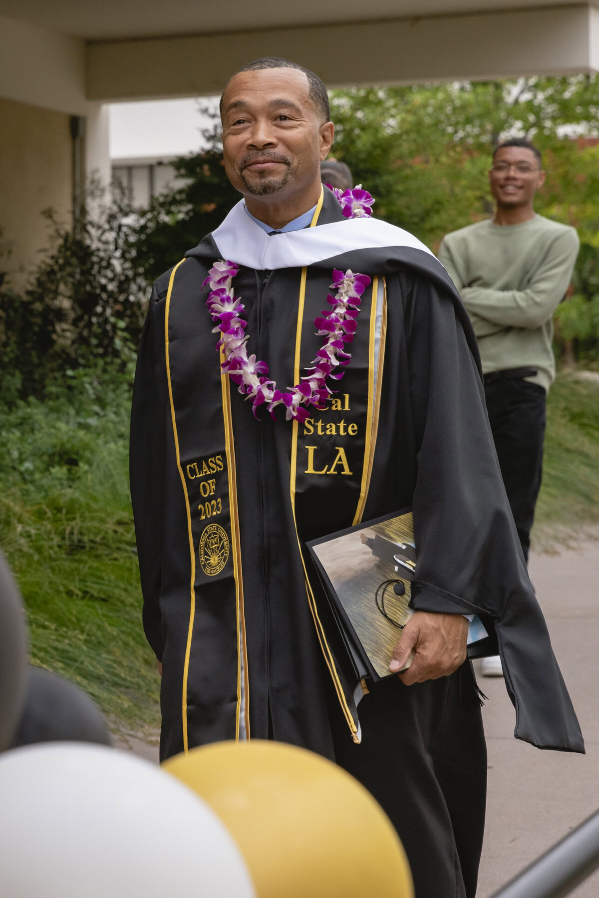 Allen Burnett walks at a graduation.