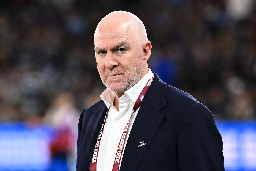 Graham Wright stands on the field wearing a suit