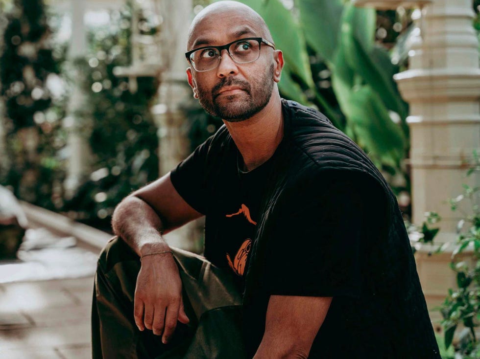 individual seated among greenery in an indoor setting