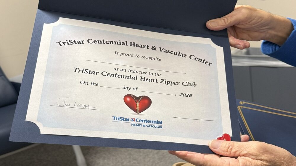 Jim's hands holding a "Zipper Club" certificate from TriStar Centennial Heart & Vascular Center