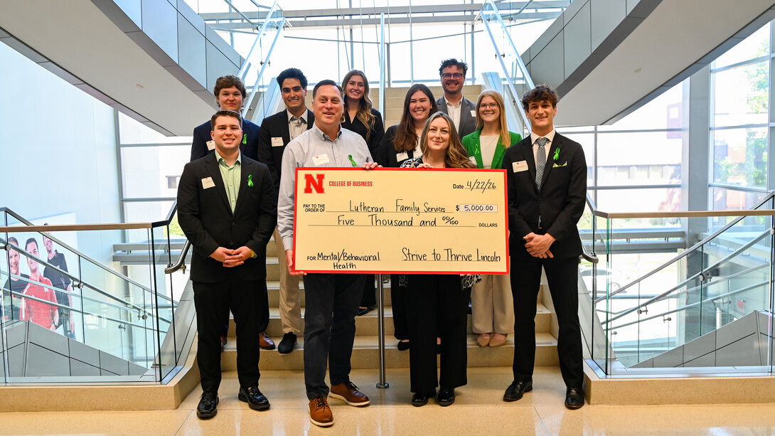 A crowd gathers around a large check to Lutheran Family Services for a picture.