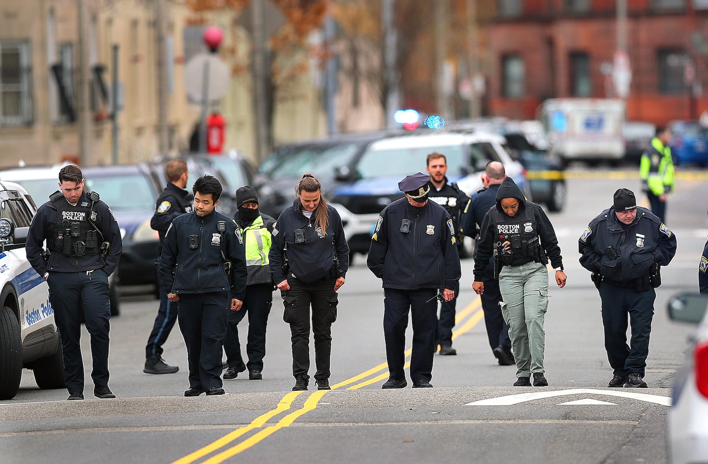Boston police formed a search line outside the scene of a shooting.  