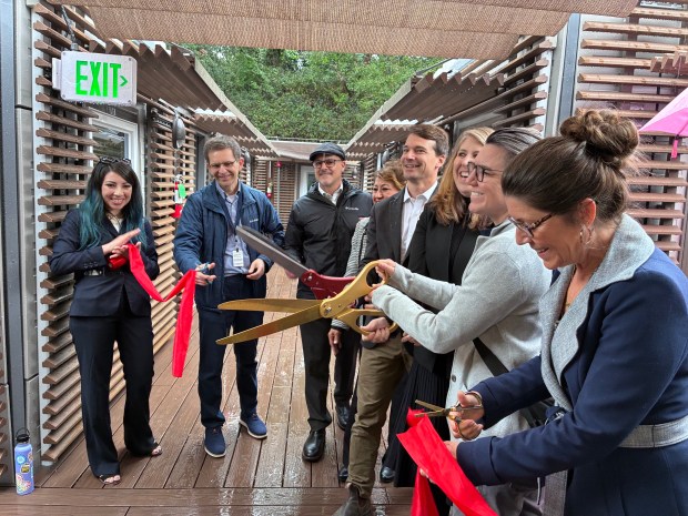 Bridge House project leaders from Santa Cruz County and Housing Matters cut a ribbon to mark the opening of the new transitional housing project.  (Gabrielle Gillette - Santa Cruz Sentinel)