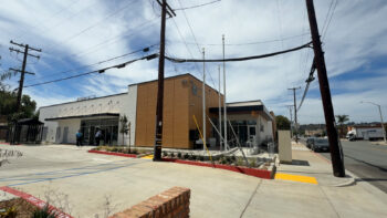 Exterior of building, wooden slats and white concrete.
