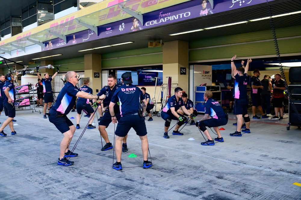 Alpine mechanics go through a warm-up routine before the race. 